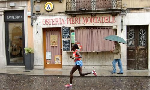 Udine Half Marathon - Maratonina di Udine, Italy - a runner at the Osteria Pieri Mortadele (Copyright © 2016 Hendrik Böttger / runinternational.eu)